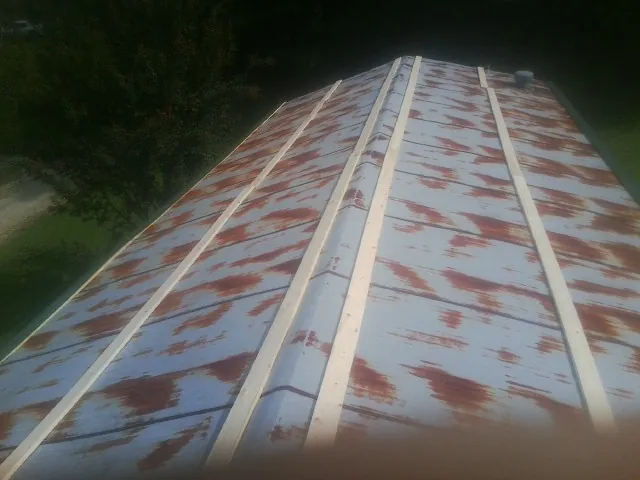 Rusted metal roof panels with new wood purlins before replacement — Storm Damage Roof Repair in Rosemary Beach by Roofing Brothers