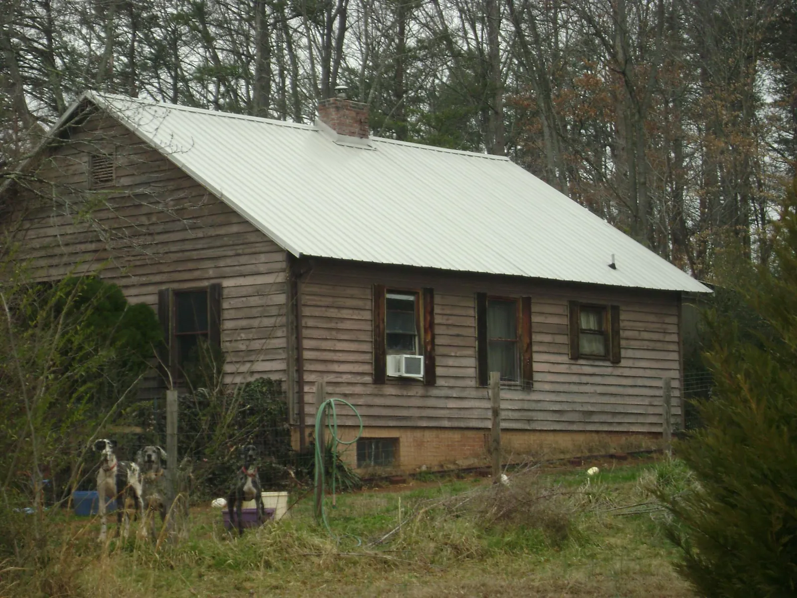 White metal roof on an old wood sided farmhouse, from a Metal Roof Installation job in Rosemary Beach